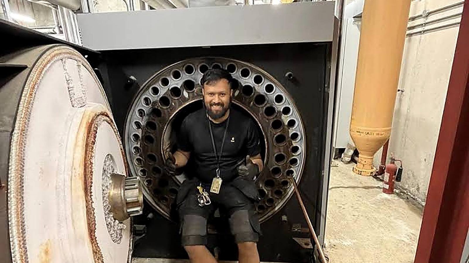 Neos Engineering engineer inside a commercial boiler in a London plant room