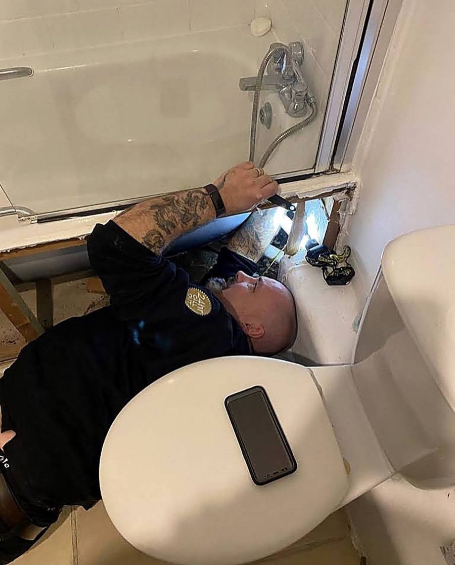 Neos Engineering engineer working on bath taps in a London bathroom