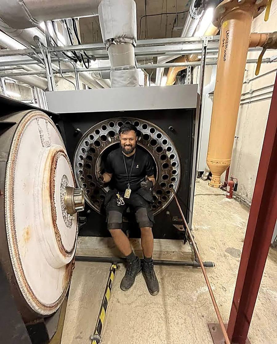 Neos Engineering engineer inside the combustion chamber of a commercial boiler in a London plant room
