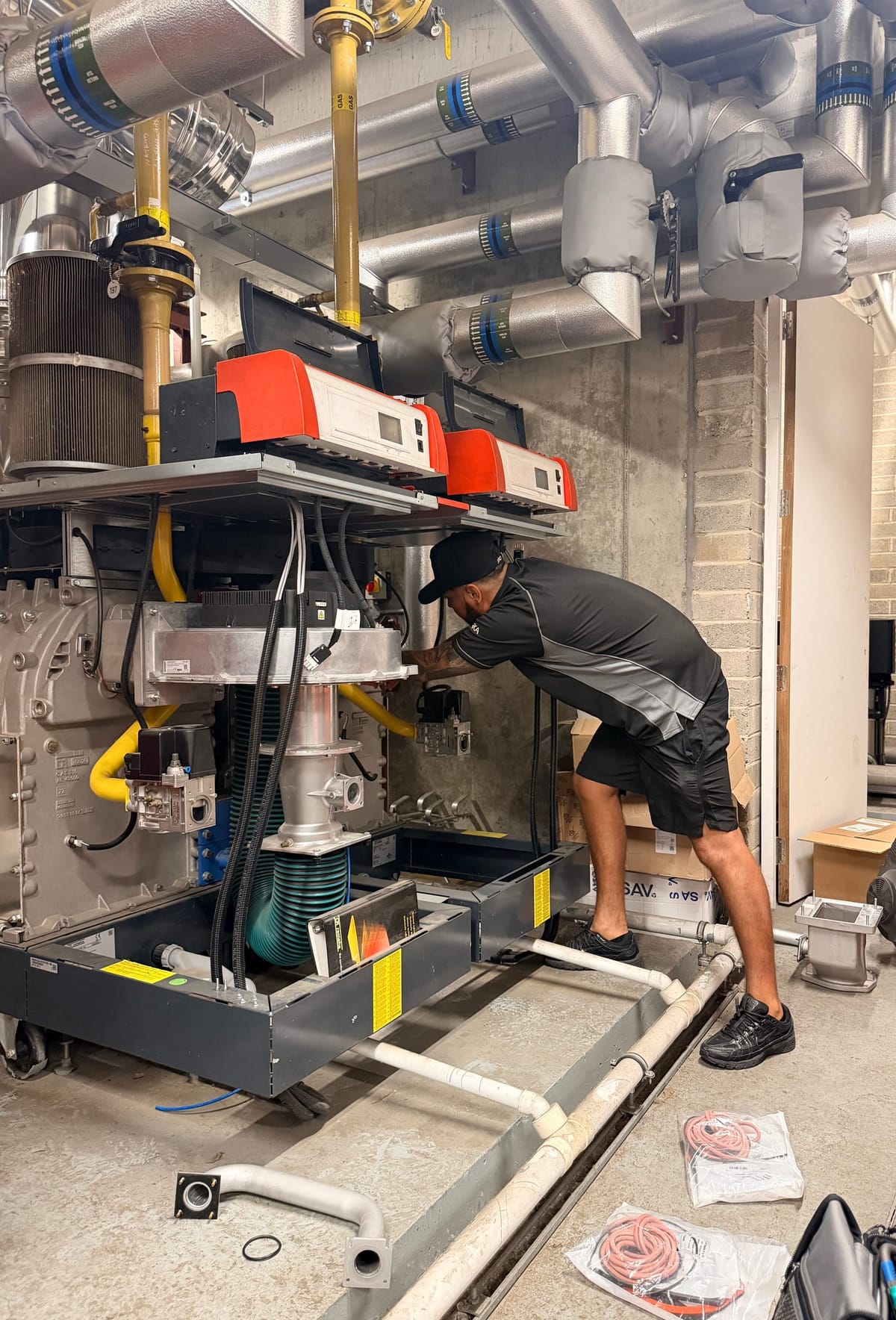 Charlie Robinson, director of Neos Engineering, working on the gas controls of commercial boiler plant in a London plant room